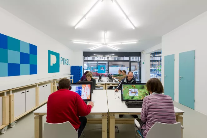 Im PIKSL-Labor Düsseldorf sitzen Menschen vor Laptops und spielen Computerspiele.