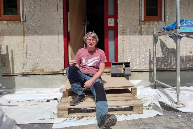 Jürgen aus Kreuzberg sitzt vor seinem zerstörten Haus. Viele Arbeiten erledigt er selbst nach Feierabend.
