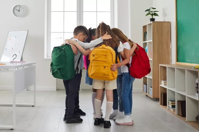 Kinder umarmen sich im Klassenzimmer.