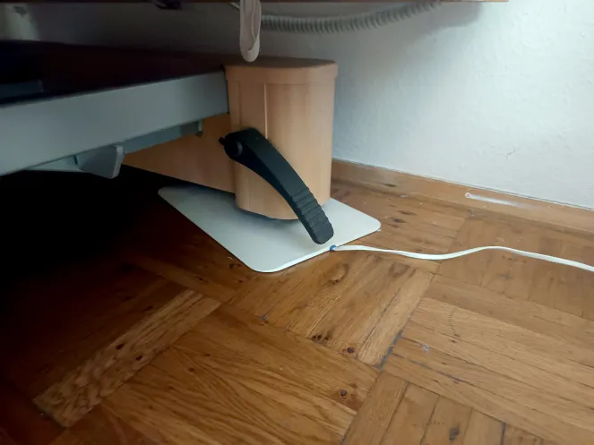 Ein Sturz-Pad mit Kabel liegt unter der Rolle eines Pflegebettes 