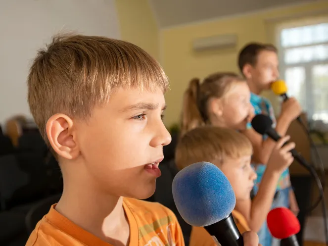 Kinder sprechen in ein Mikrofon