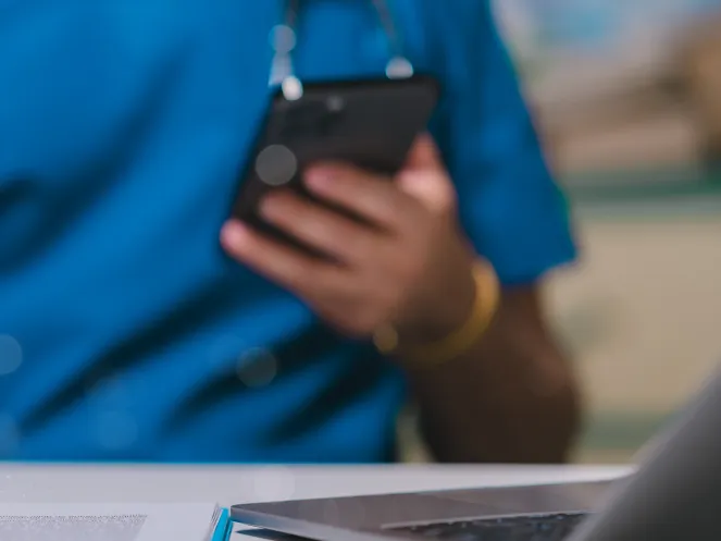 Eine Pfleger schaut auf sein Handy