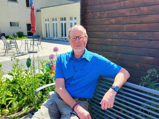 Ein Mann sitzt auf einer Bank