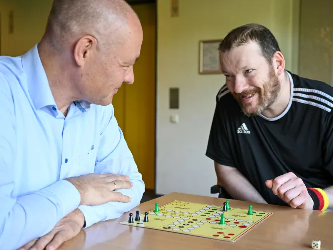 Michael Schwarz (r.) freut sich über eine weitere gewürfelte Sechs beim „Mensch ärgere dich nicht“ mit Pastor Dr. Bartolt Haase.
