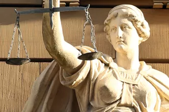 Statue Justitia hält Waage und Schwert.