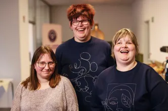 Drei Frauen lachen in die Kamera.