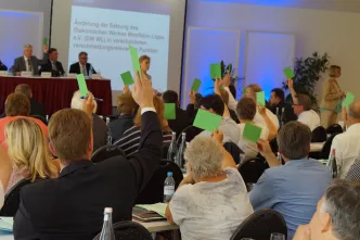 In einem großen Saal halten die Delegierten grüne Karten hoch