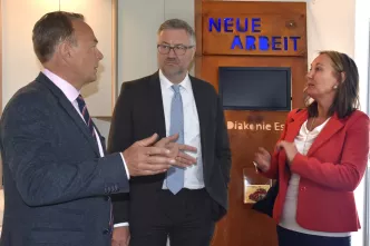 Gruppenfoto vor Schild "Neue Arbeit Essen"