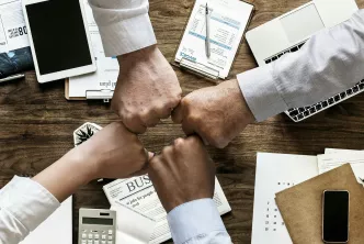 Hände symbolisieren Zusammenhalt im Büro