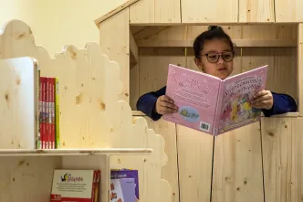 Mädchen liest in der OGS ein Buch.