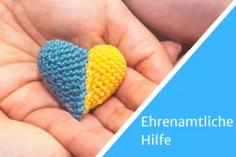 Hand hält Herz in Farben der Ukraine