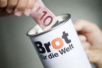 10 Euro werden in Spendendose gesteckt