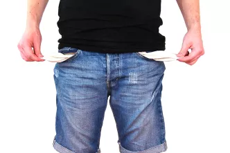 Kein Geld: Mann zeigt seine leeren Hosentaschen.