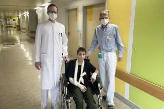 Chefarzt Frank Hartmann und Christoph von Buch, ärztlicher Direktor, mit dem elfjährigen David, der einen Tag nach seiner Operation noch im Rollstuhl sitzt. 