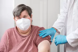 Eine Frau mit Behinderung lässt sich gegen das Corona-Virus impfen.
