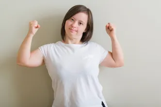 Junge Frau mit Down-Syndrom zeigt, wie stark sie ist.