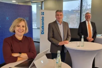 Die Diakonie RWL-Vorstände Kirsten Schwenke und Christian Heine-Göttelmann stehen mit Landesjugendamtsleiter Lorenz Bahr-Hedemann (Mitte) zusammen.