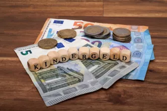 Geldscheine und Buchstaben "Kindergeld" auf einem Haufen
