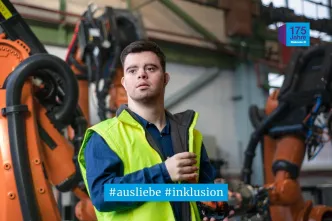 Junger Mann mit Downsyndrom arbeitet in einer Werkstatt für behinderte Menschen.
