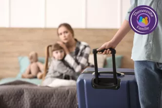 Frau mit Kind sitzt auf einem Bett während der Mann mit einem Koffer das Zimmer verlässt