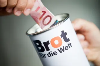 10 Euro werden in Spendendose gesteckt