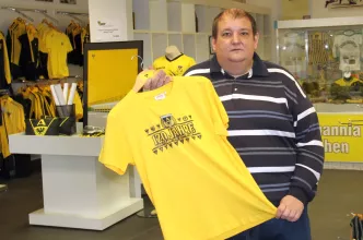 Markus Mingers zeigt ein T-Shirt im Alemannia Aachen-Shop des diakonischen Beschäftigungsträgers WABe (Foto WABe)s