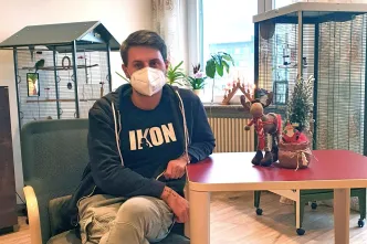 Pfleger Marc Schneider sitzt im weihnachtlich dekorierten Paul Marien Hospiz Saarbrücken der Stiftung kreuznacher diakonie. 
