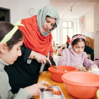 Eine Frau und zwei Mädchen arbeiten in der Küche