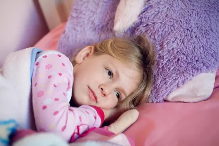 Mädchen liegt traurig im Bett